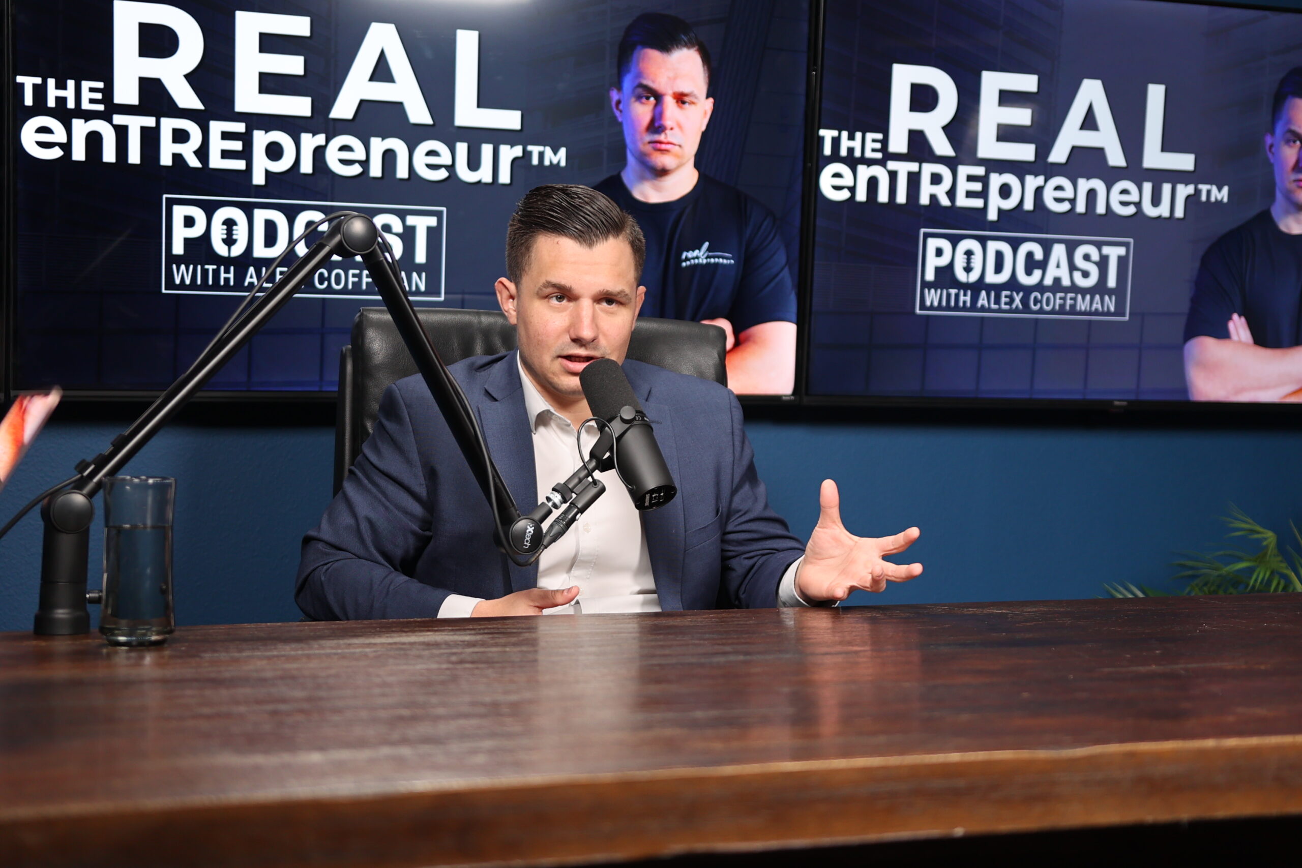 man in blue suit doing a podcast